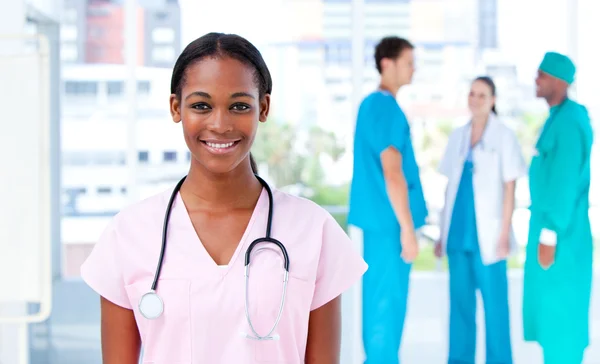 Médica feminina confiante em pé com sua equipe — Fotografia de Stock