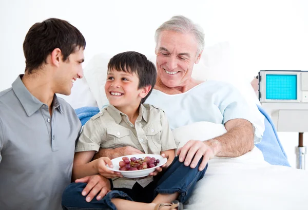 Glimlachend vader en zijn zoon bezoekende grootvader — Stockfoto