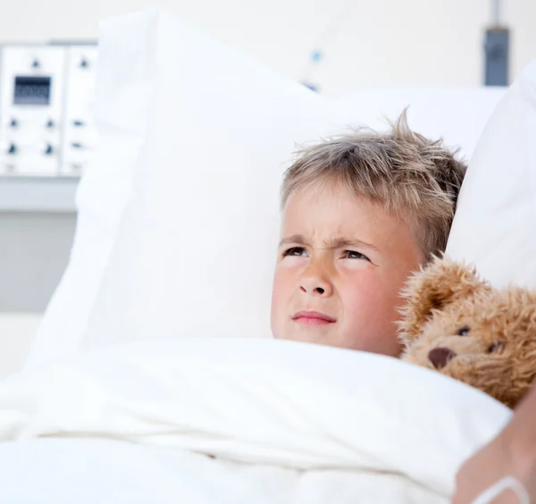 Sick little boy lying in a hospital bed — Stock Photo, Image