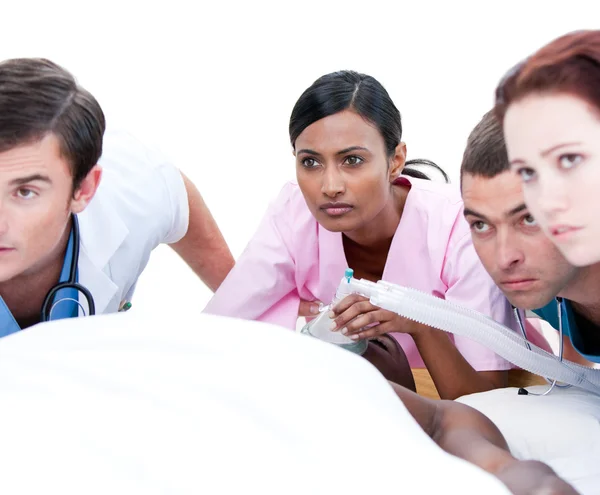 Selbstbewusstes multiethnisches Ärzteteam reanimiert einen Patienten — Stockfoto