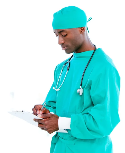 Cirurgião carismático do sexo masculino fazendo anotações na pasta de um paciente — Fotografia de Stock
