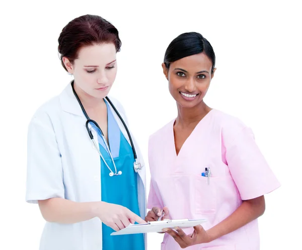 Médica e enfermeira confiante estudando a pasta de um paciente — Fotografia de Stock