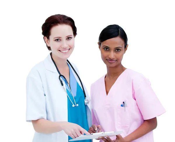 Sel-assured female doctor and nurse studying a patient's folder — Stock Photo, Image
