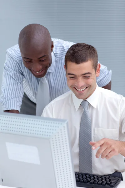 Empresários caucasianos e afro-americanos usando um laptop — Fotografia de Stock