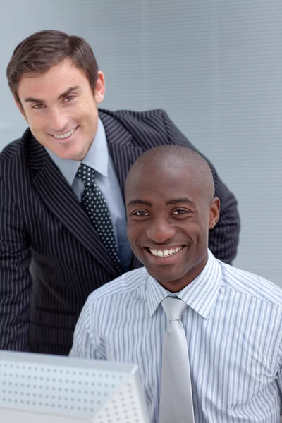 Biznesmeni uśmiechający się ze sobą za pomocą komputera — Zdjęcie stockowe