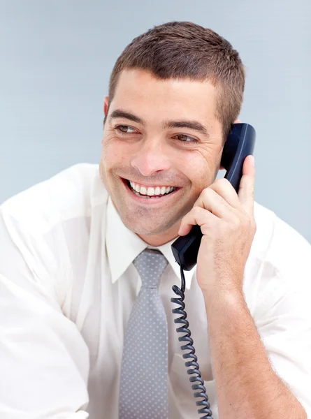 Улыбающийся бизнесмен в офисе разговаривает по телефону — стоковое фото
