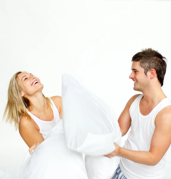 Jeune couple ayant une bataille d'oreillers avec copie-espace — Photo