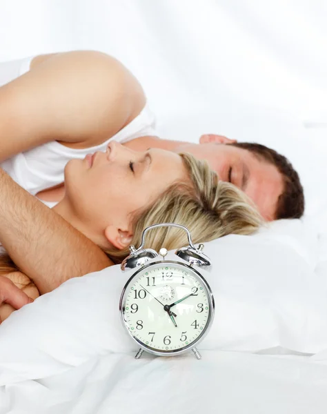 Para w łóżku z naciskiem w budzik — Zdjęcie stockowe