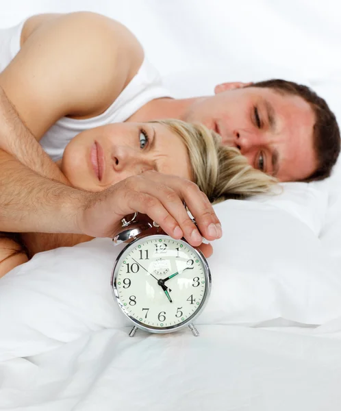 目覚まし時計をオフに行くとベッドでカップル — ストック写真
