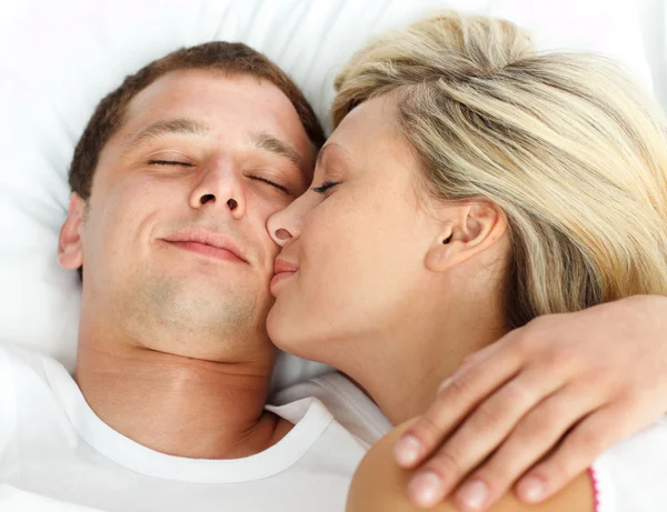 Flickvän kysser sin pojkvän i sängen — Stockfoto
