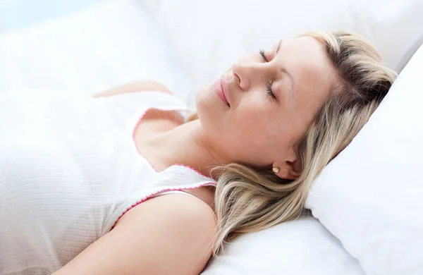 Schöne junge Frau schläft auf einem Bett — Stockfoto