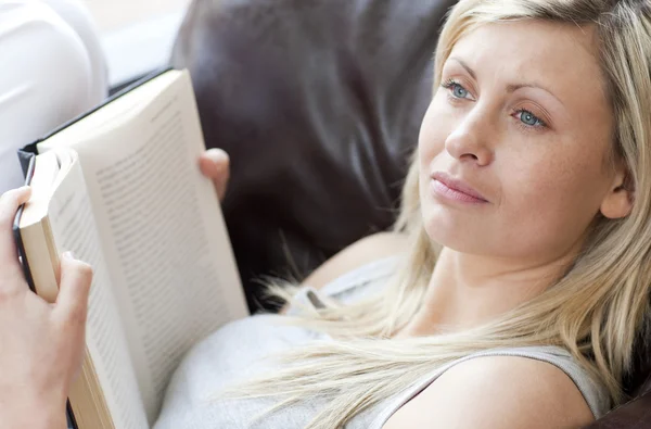 Piękna kobieta, czytanie książki, siedząc na kanapie — Zdjęcie stockowe