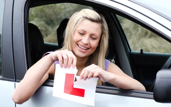 Glückliche junge Autofahrerin zerreißt ihr Schild — Stockfoto