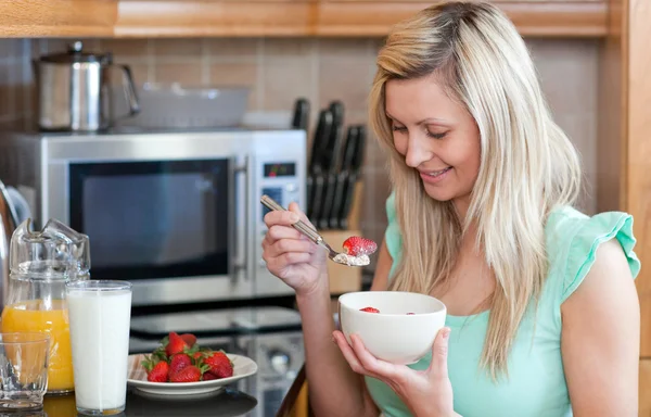 Mulher alegre tendo um café da manhã saudável em uma cozinha — Fotografia de Stock