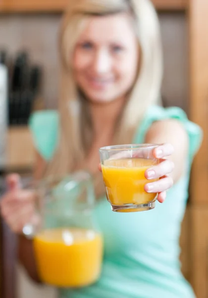 Молодая женщина держит стакан апельсинового сока во время исцеления — стоковое фото