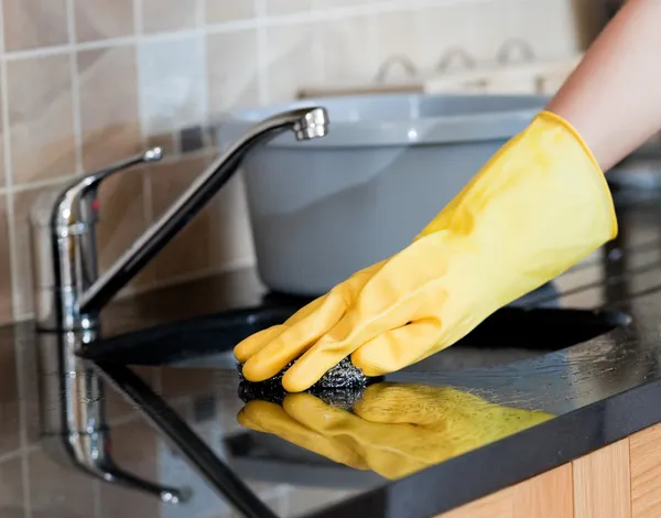 Primer plano de una mujer limpiando una cocina — Foto de Stock