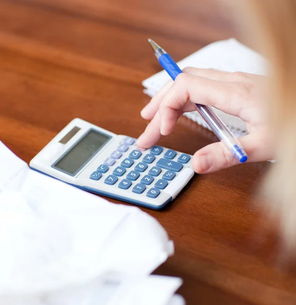 Close-up of a blond woman paying her bills — Stock Photo, Image
