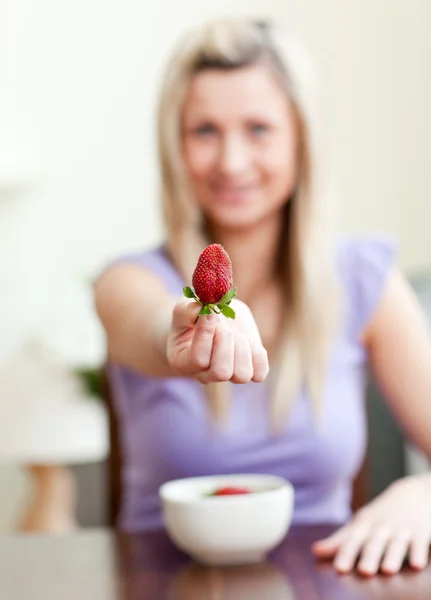 Portrait of a woman showing a strawberry — Stock Photo, Image