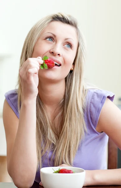 Porträt einer schönen Frau, die eine Erdbeere isst — Stockfoto