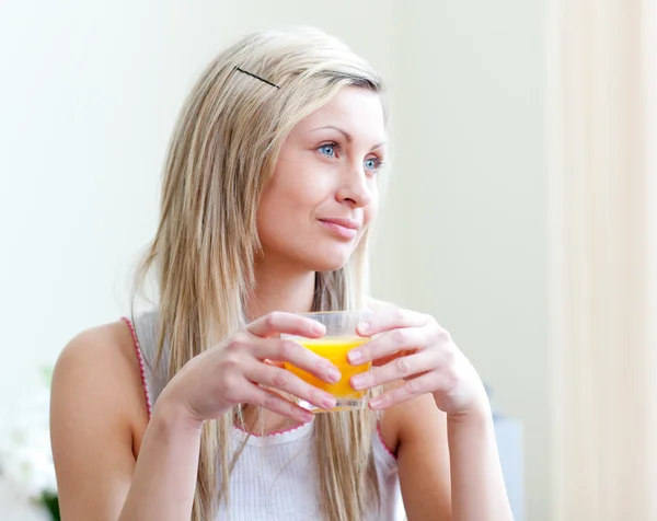 Porträtt av en avslappnad ung kvinna dricka en apelsinjuice — Stockfoto