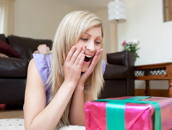 Překvapen žena otevřít dárky, ležící na podlaze — Stock fotografie