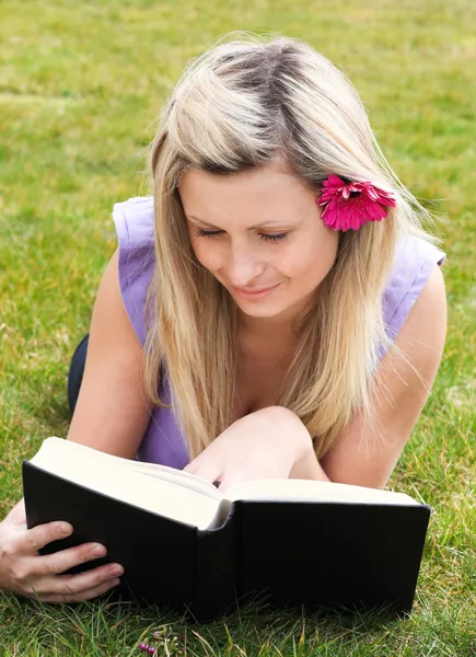Γοητευτική γυναίκα διαβάζοντας ένα βιβλίο σε ένα πάρκο — Φωτογραφία Αρχείου
