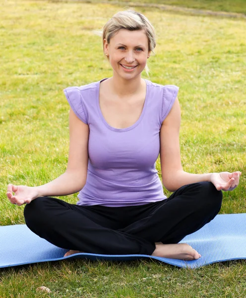 Smiling woman meditating sitting on the grass — Stock Photo, Image