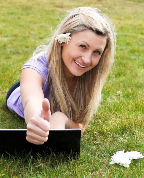 Mutlu genç kadın parkta bir dizüstü bilgisayar kullanarak — Stok fotoğraf
