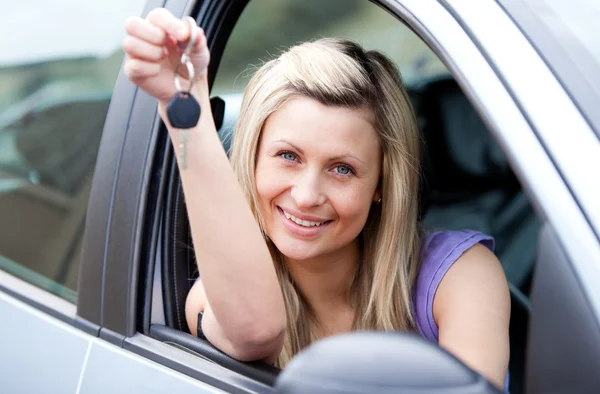 Attractive young driver holding a key after bying a new car — Stock Photo, Image