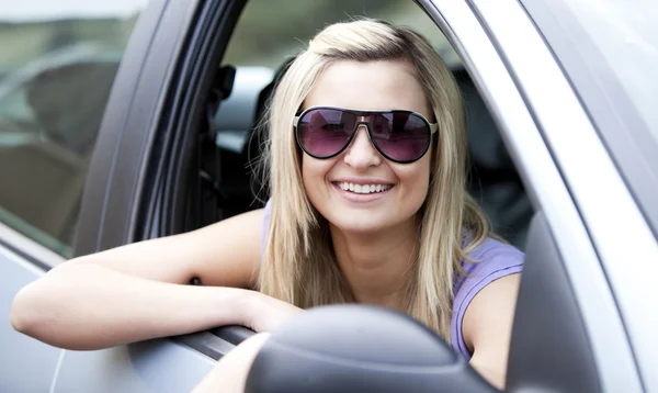 Wesoły kobieta kierowca nosi okulary, siedział w swoim samochodzie — Zdjęcie stockowe