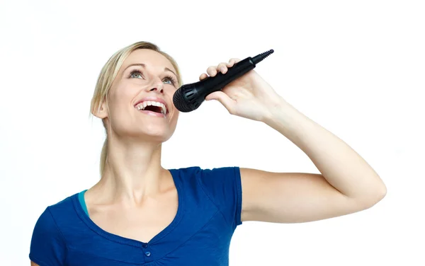 Mujer cantando en un micrófono sobre fondo blanco — Foto de Stock