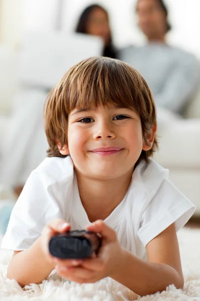 Entzückender kleiner Junge vor dem Fernseher auf dem Boden liegend — Stockfoto