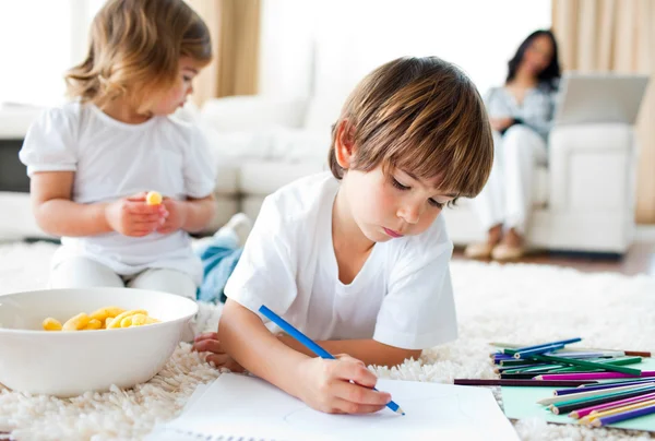 Happy children eating chips and drawing — Stock Photo, Image