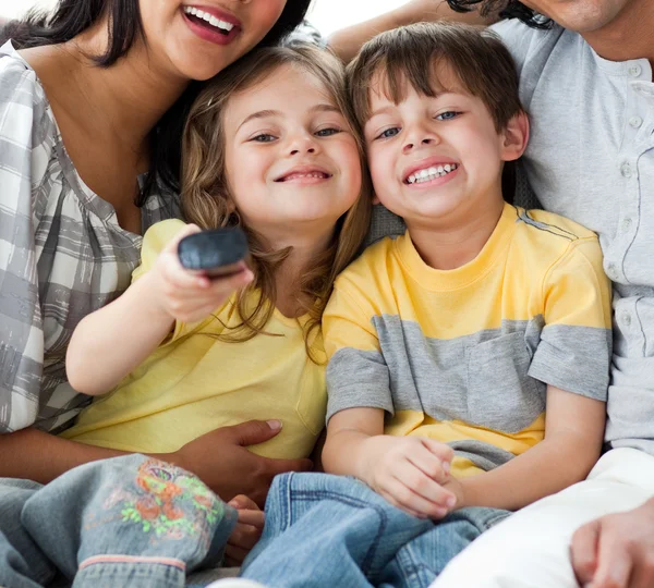 Roztomilé děti, sledování televize s rodiči — Stock fotografie
