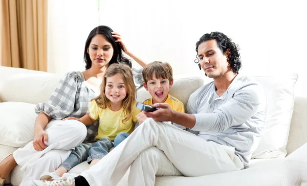 Menino animado assistindo TV com sua família — Fotografia de Stock