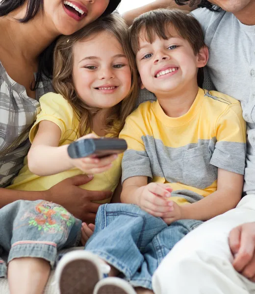 Crianças adoráveis assistindo TV com seus pais — Fotografia de Stock