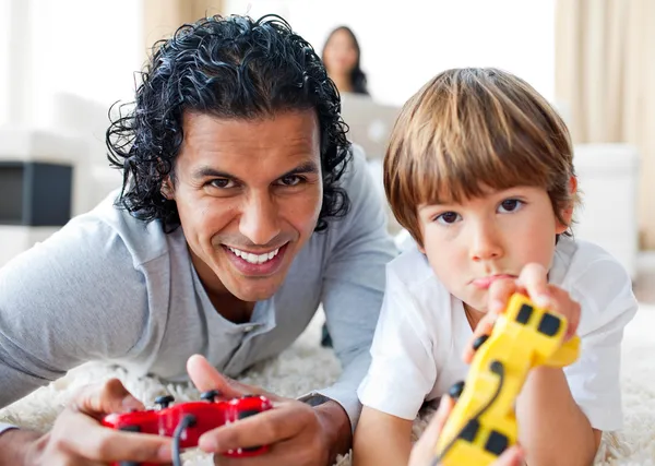 快乐的父亲和他的儿子在玩视频游戏躺在地板上 — 图库照片