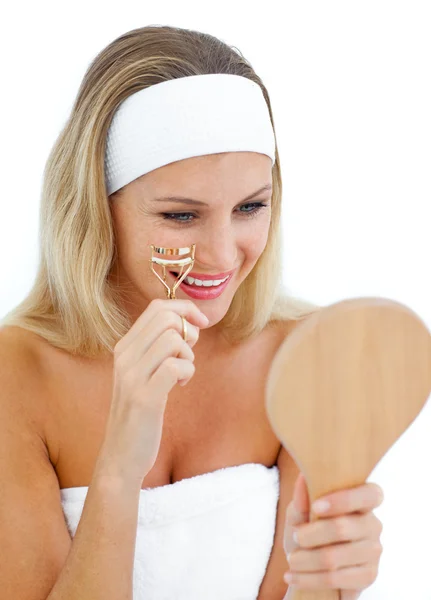 Mulher sorridente usando um frisador de pestanas — Fotografia de Stock