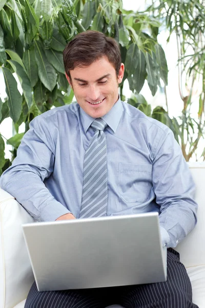 Kanepenin üzerinde bir dizüstü bilgisayar kullanarak iş adamı — Stok fotoğraf