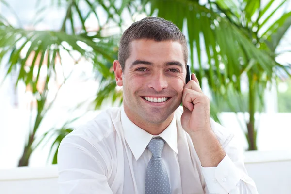 Friendly businessman on phone sitting on a couch — Stock Photo, Image