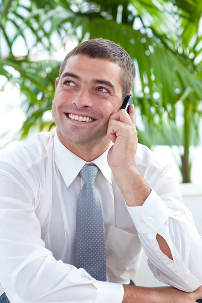 Бизнесмен сидит на диване и говорит по мобильному телефону — стоковое фото
