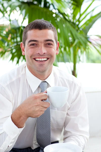 Businessman drinking a cup of tea in workplace — Stock Photo, Image