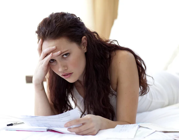 Beautiful woman in bed getting frustrated with bills — Stock Photo, Image