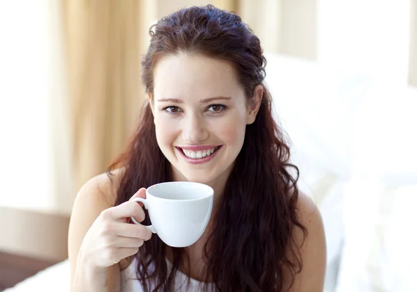 寝室にコーヒーのカップを飲む女性の笑みを浮かべてください。 — ストック写真