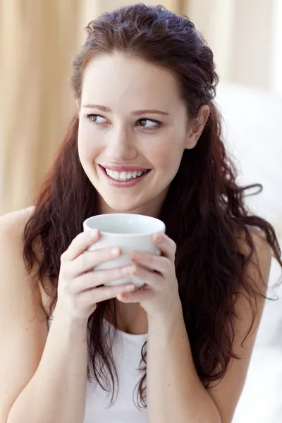 Όμορφη γυναίκα πίνοντας ένα φλιτζάνι καφέ στο κρεβάτι — Φωτογραφία Αρχείου
