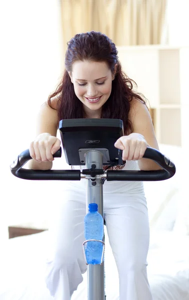 Beautiful woman doing spinning at home — Stock Photo, Image