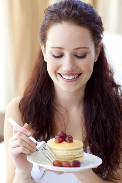 Leende kvinna äter en söt dessert — Stockfoto