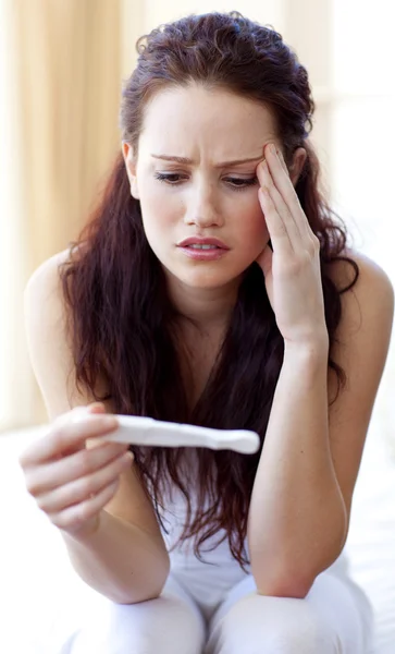 Жінка дивиться на тест на вагітність — стокове фото