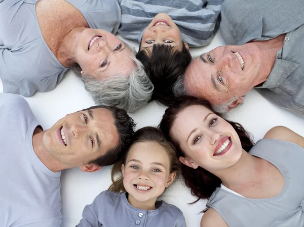 Счастливая семья лежит на полу с головами вместе — стоковое фото
