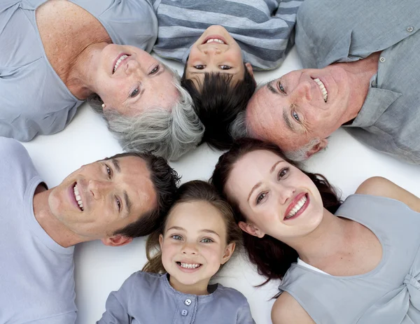Alto ángulo de la familia acostada en el suelo con cabezas juntas — Foto de Stock